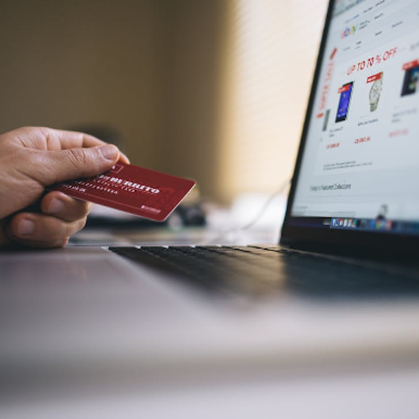 Computer Beside Person Holding Red Smart Card 