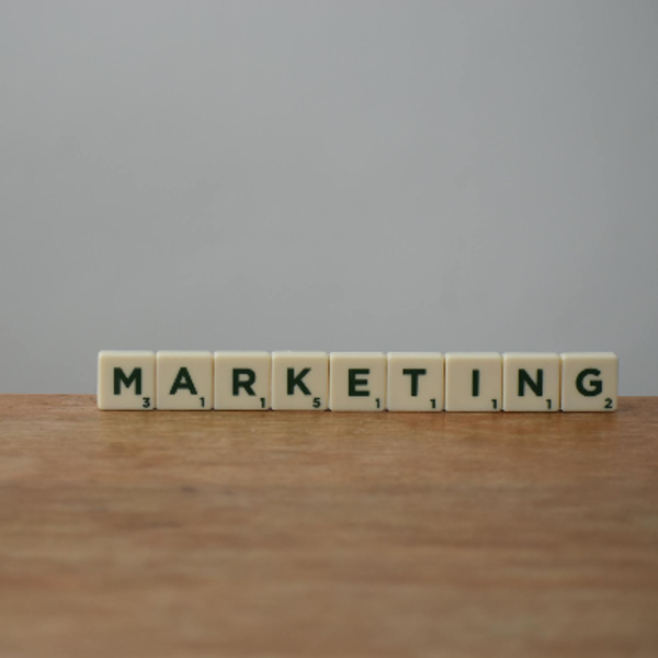 White and Black Marketing Word on Brown Wooden Table