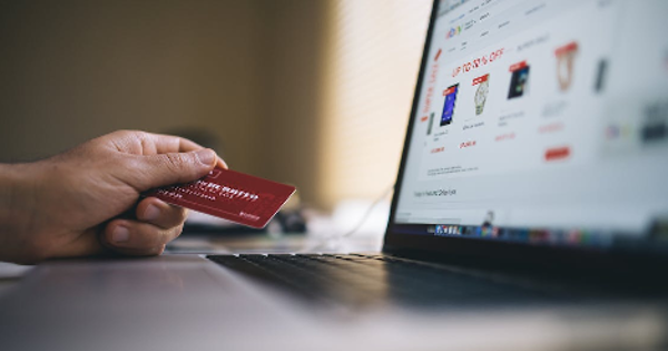 Computer Beside Person Holding Red Smart Card 