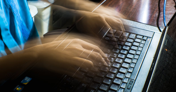 Crop unrecognizable man typing on laptop