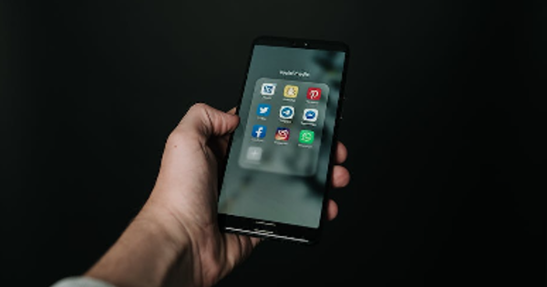 Photo of Hand Holding a Black Smartphone in Dark Background