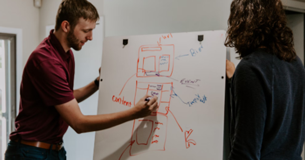 man drawing on dry-erase board