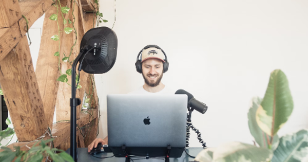 man in black headphones and macbook