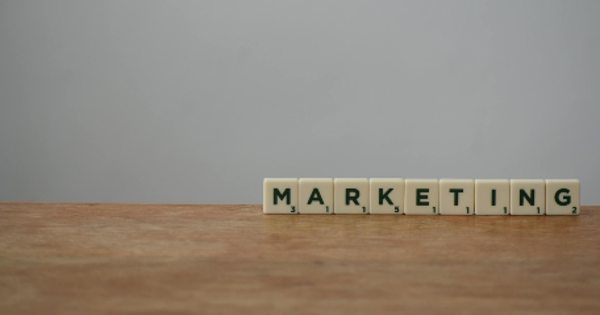 White and Black Marketing Word on Brown Wooden Table