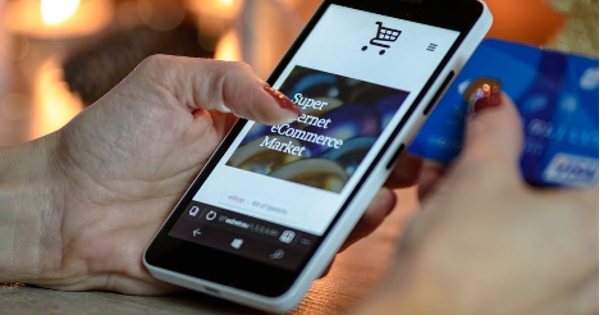 Person Using Black And White Smartphone and Holding Blue Card