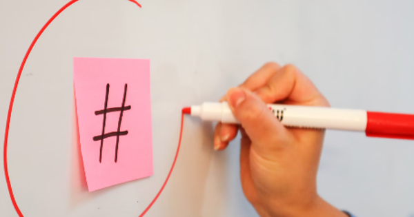 a person writing on a piece of paper with a marker