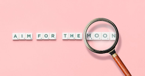 Phrase and Magnifying Glass on Pink Background