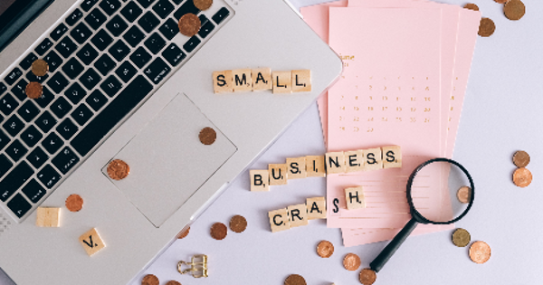 Small Business Crash Scrabble Tiles on Laptop and Table Top with Coins