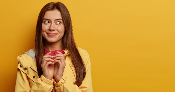 Woman looks with intention in front of yellow wall