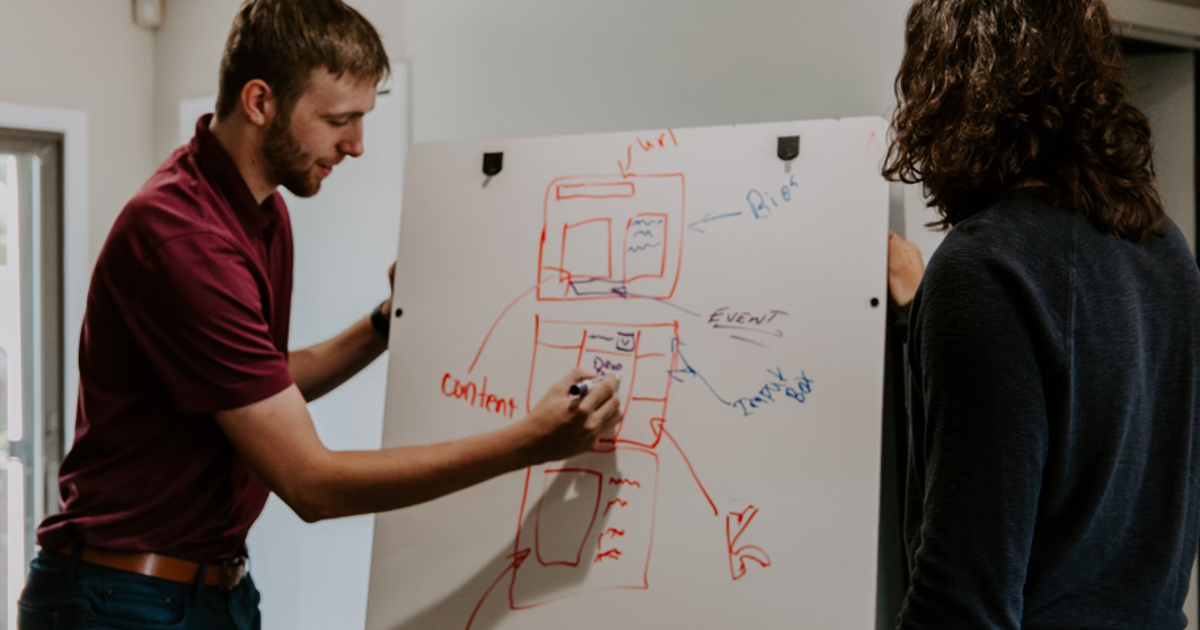 man drawing on dry-erase board