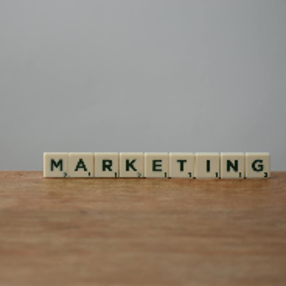 White and Black Marketing Word on Brown Wooden Table